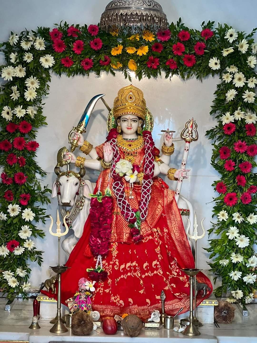 Ambe Maa surrounded by vibrant flowers