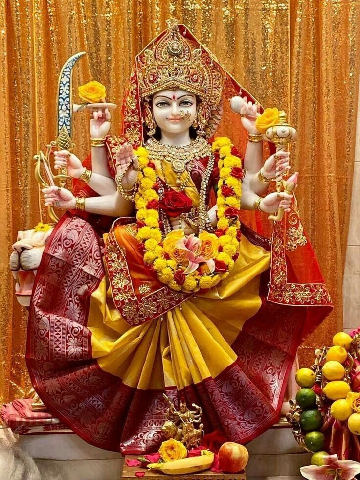 Golden ambe maa statue with flowers