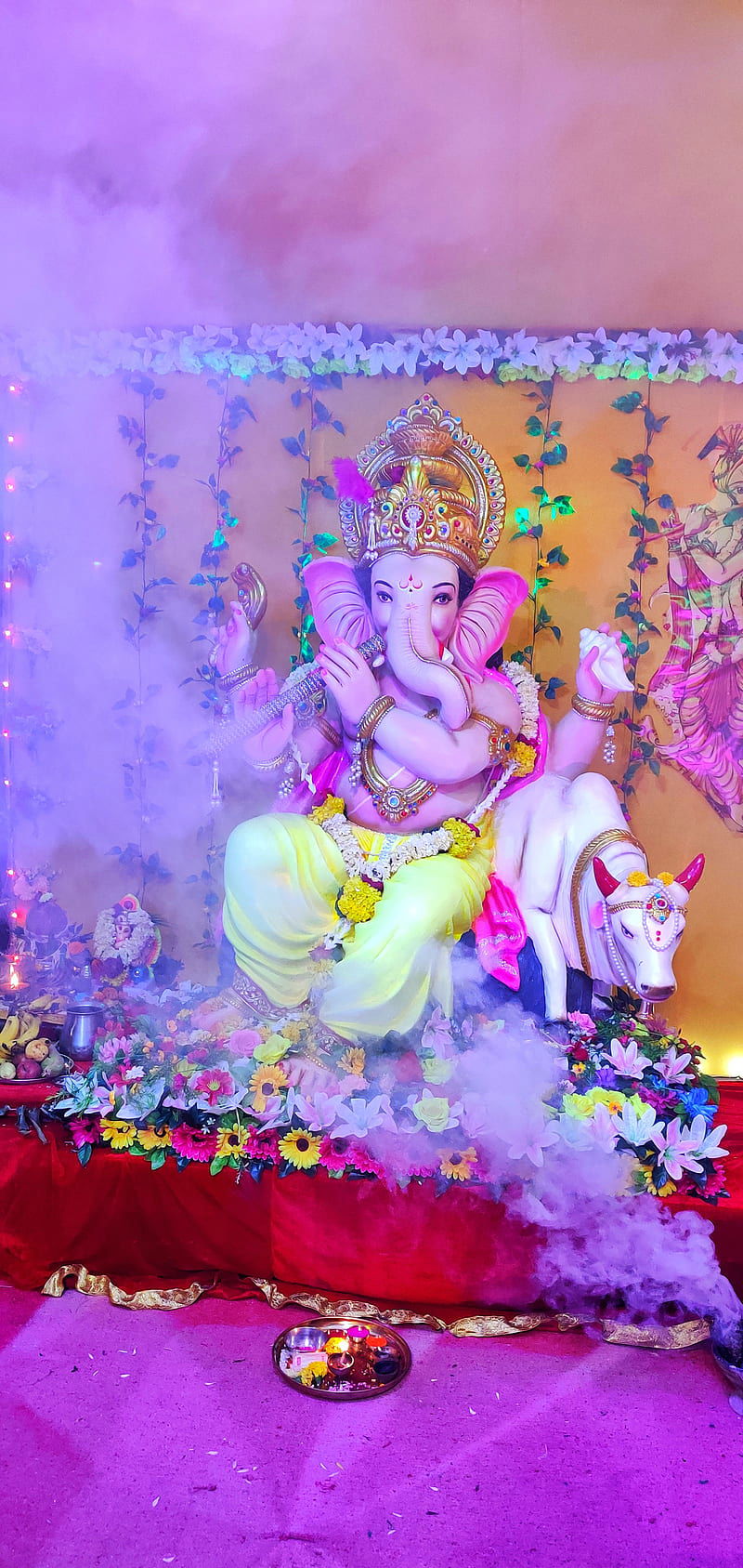 Ganesha statue with flowers and incense