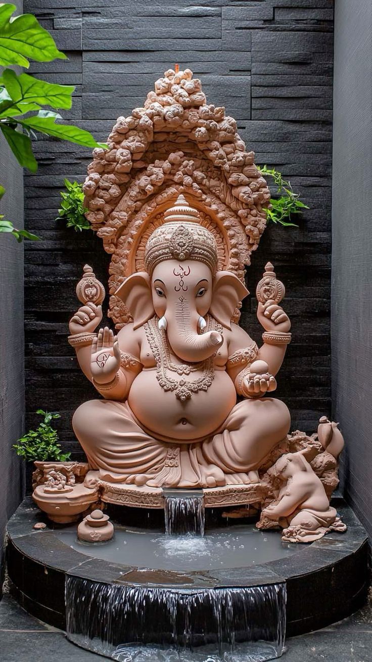 Earthen Ganesha statue with waterfall backdrop