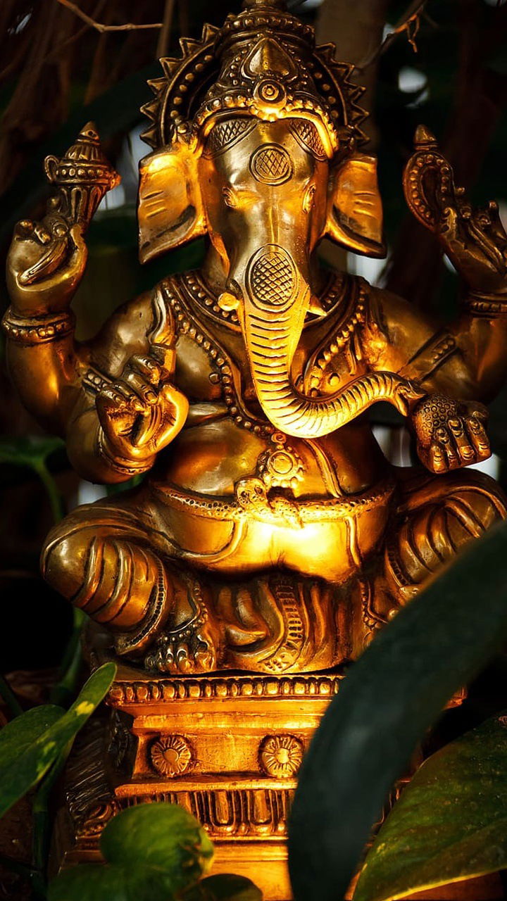 Golden Ganesha statue with modak