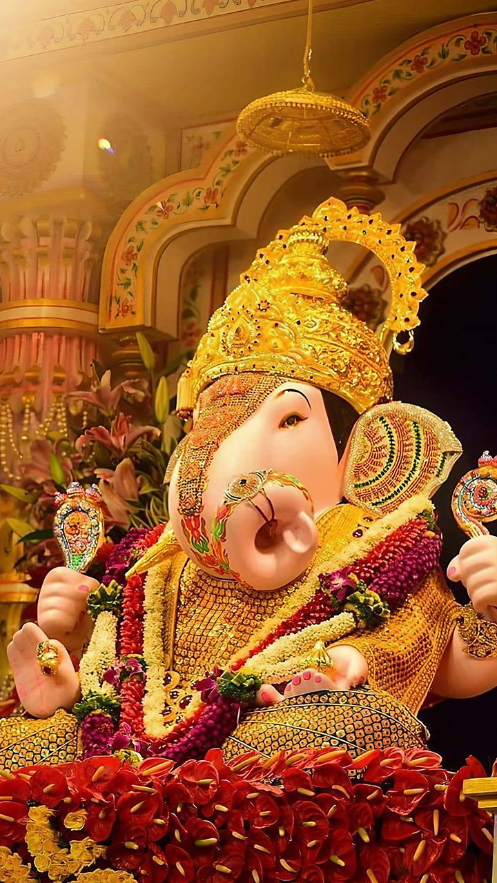 Golden Ganesha idol with floral decorations