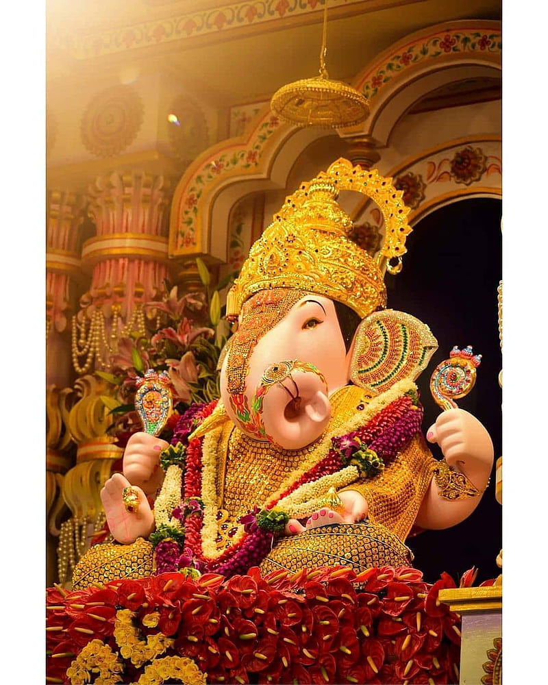 Golden Ganesha idol adorned with flowers