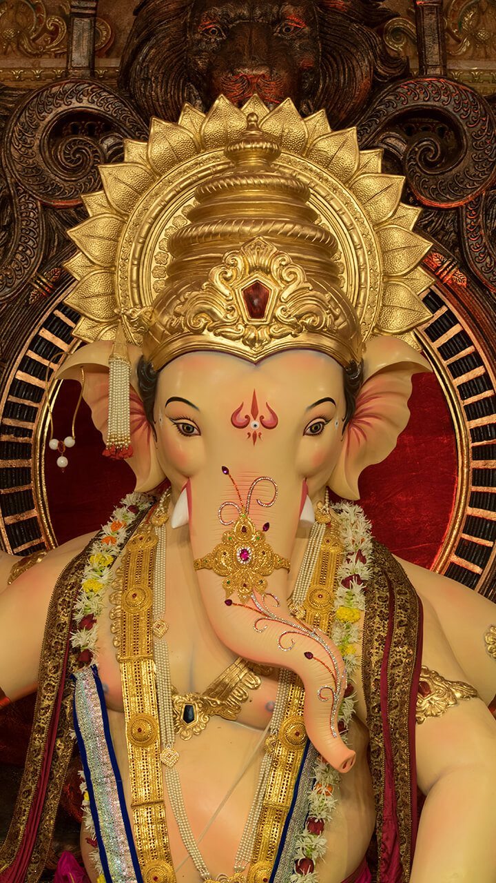 Golden Ganesha idol with flower garland