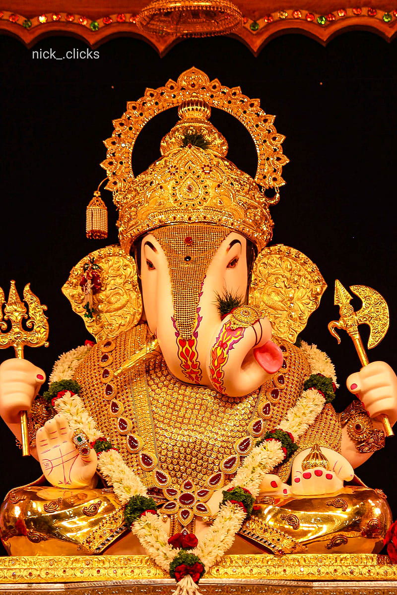 Golden Ganesha idol with floral decorations