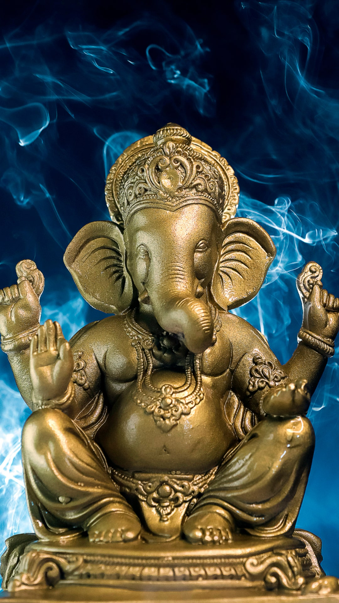 Golden Ganesha statue with smoke background