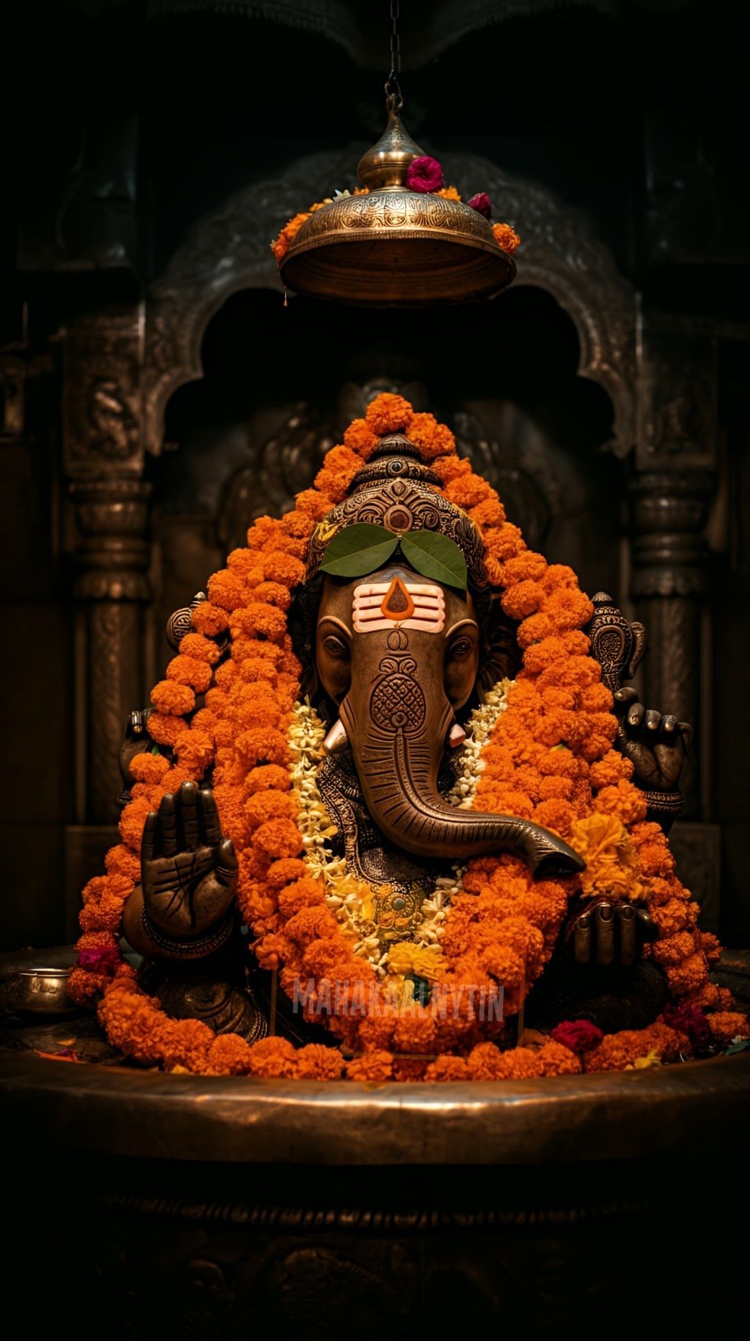 Ganesha idol adorned with orange flowers