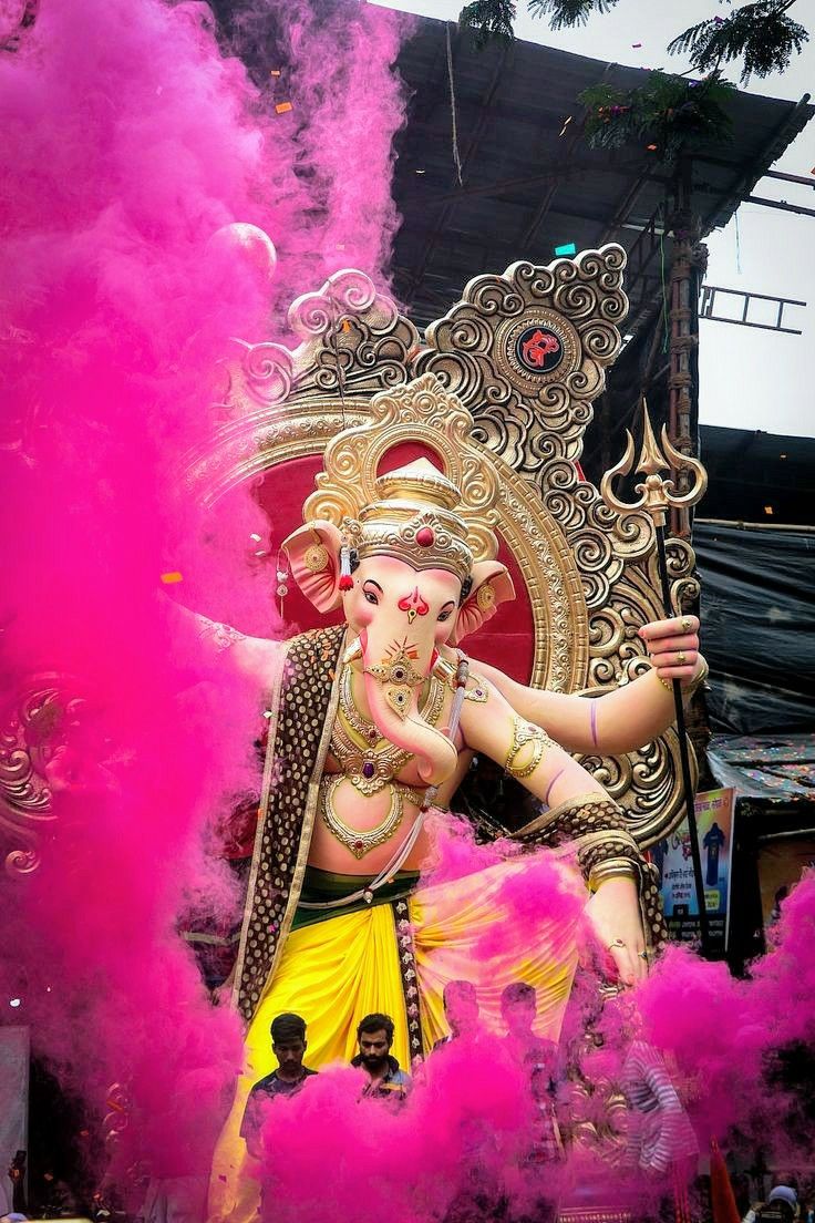 Lord Ganesha amidst pink festival smoke.