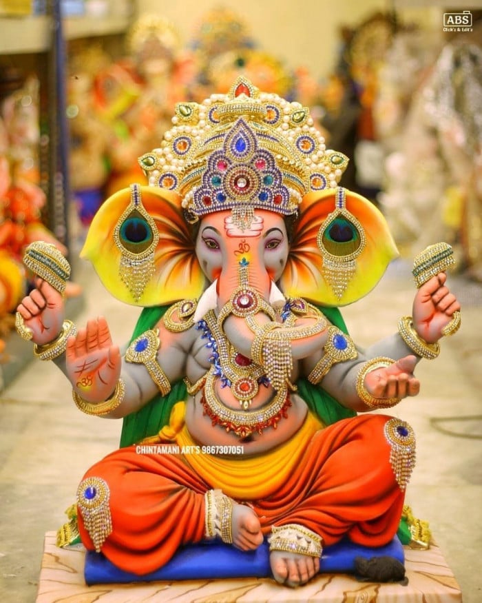 Lord Ganesha with modak and peacock feathers