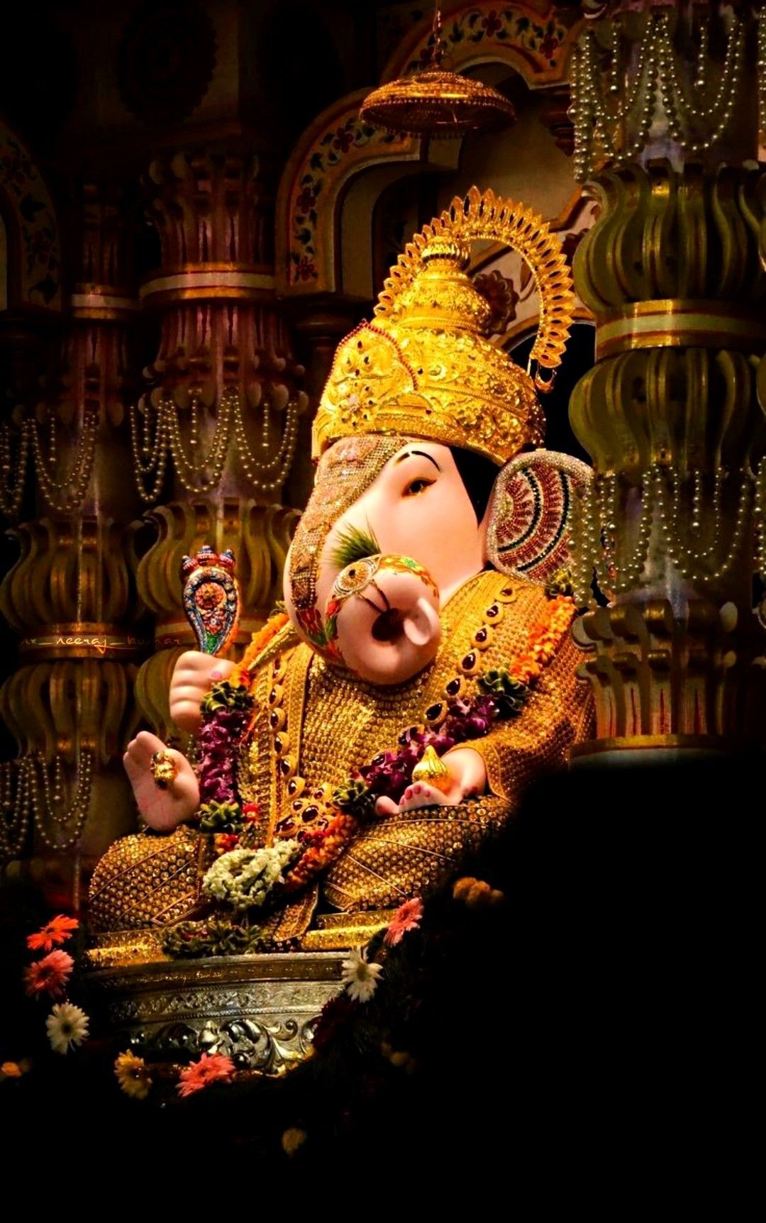 Golden Ganesha idol with flower garland