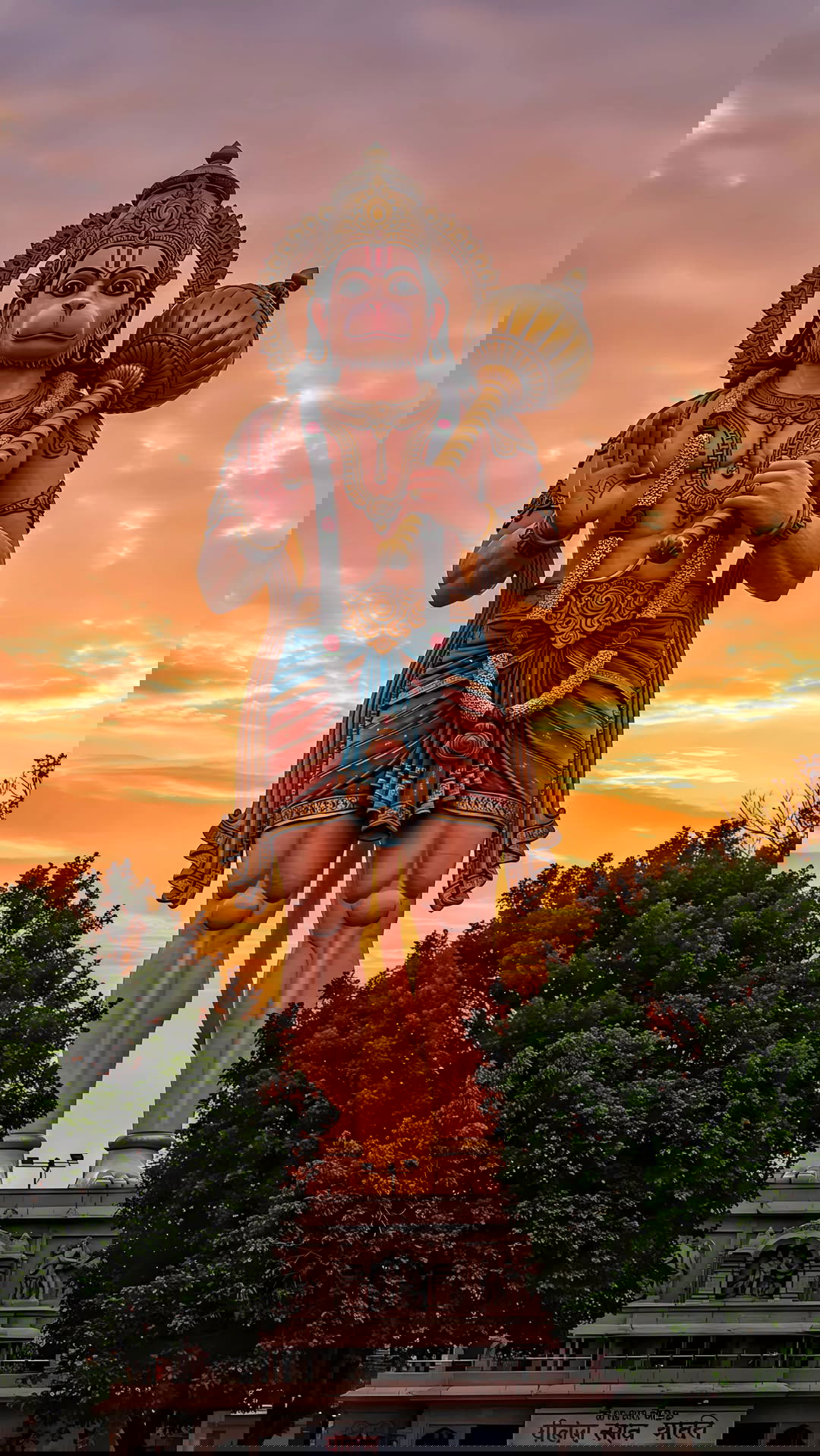 Hanuman standing with mace at sunset