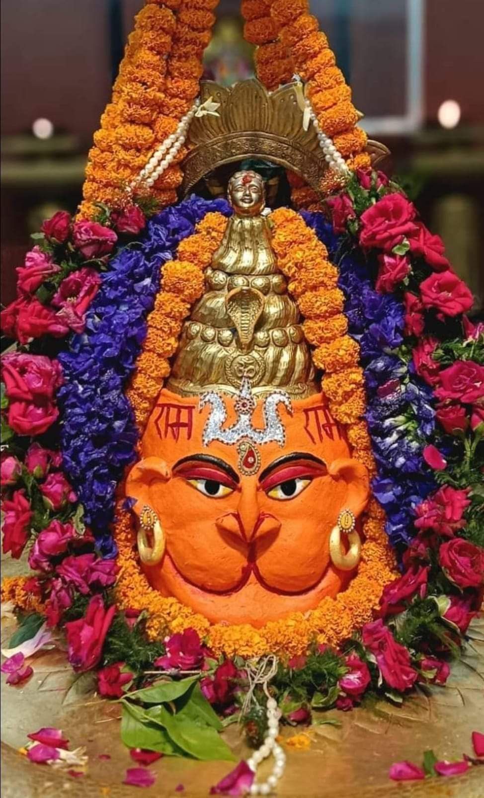 Hanuman face adorned with vibrant flowers.