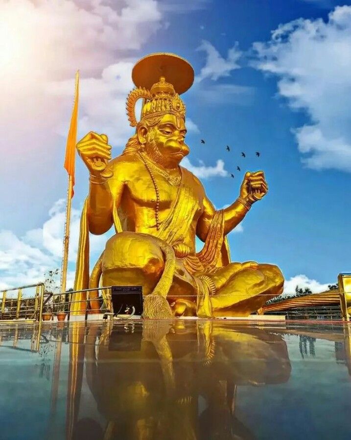 Golden Hanuman statue against cloudy sky