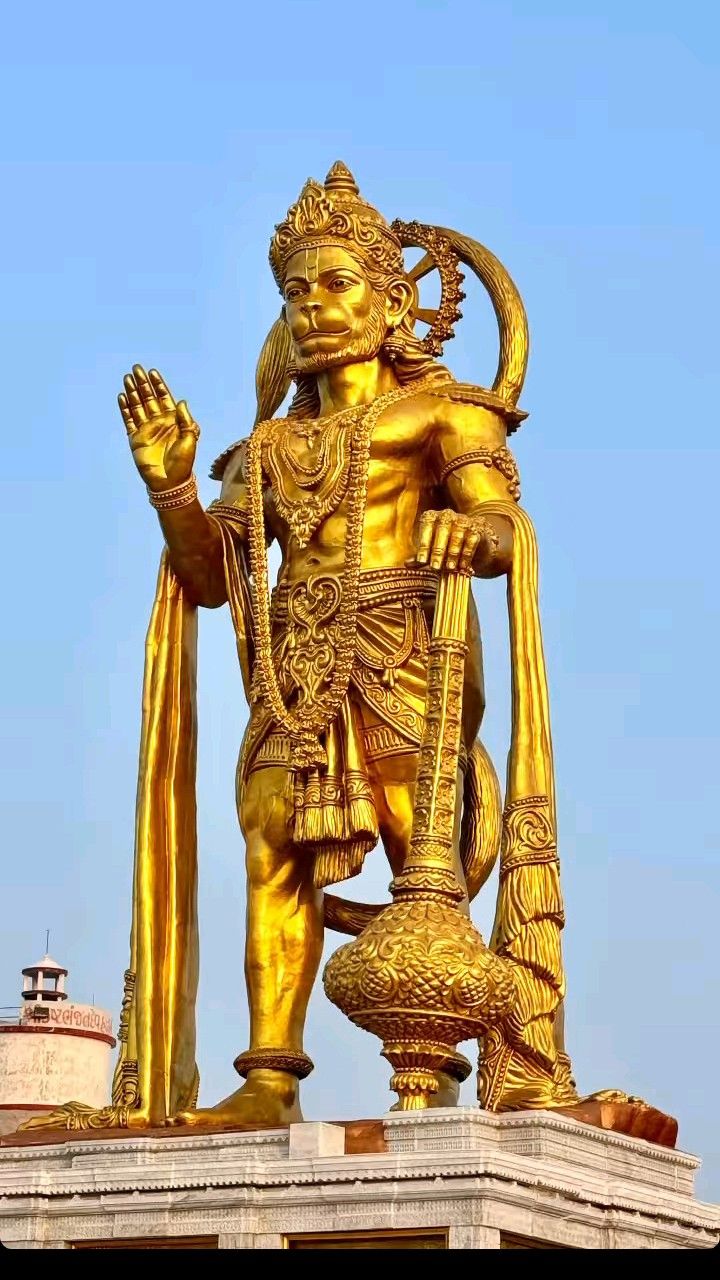 Golden Hanuman statue offering blessings.