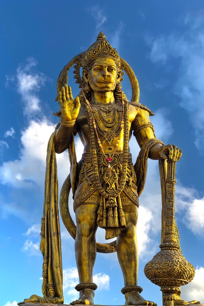 Golden Hanuman statue against blue sky