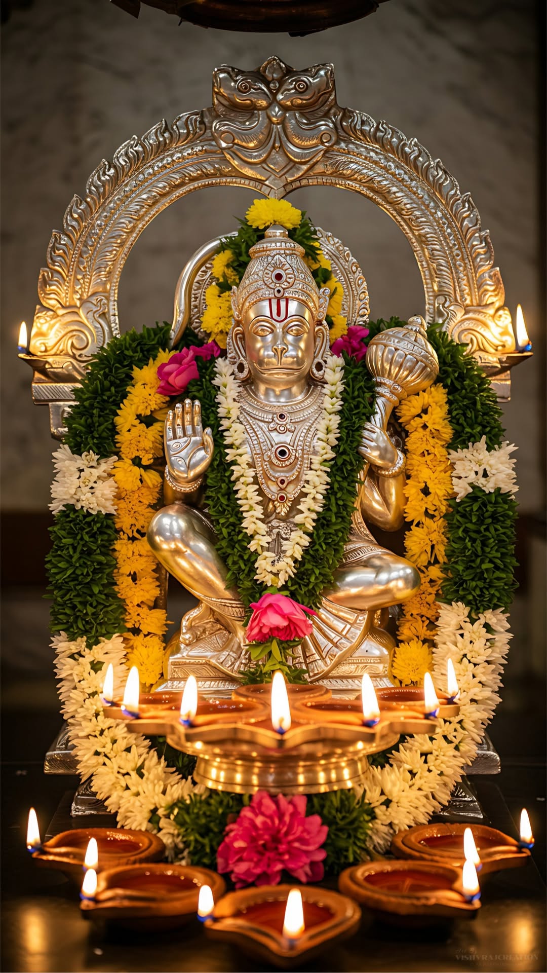 Golden Hanuman statue with floral offerings