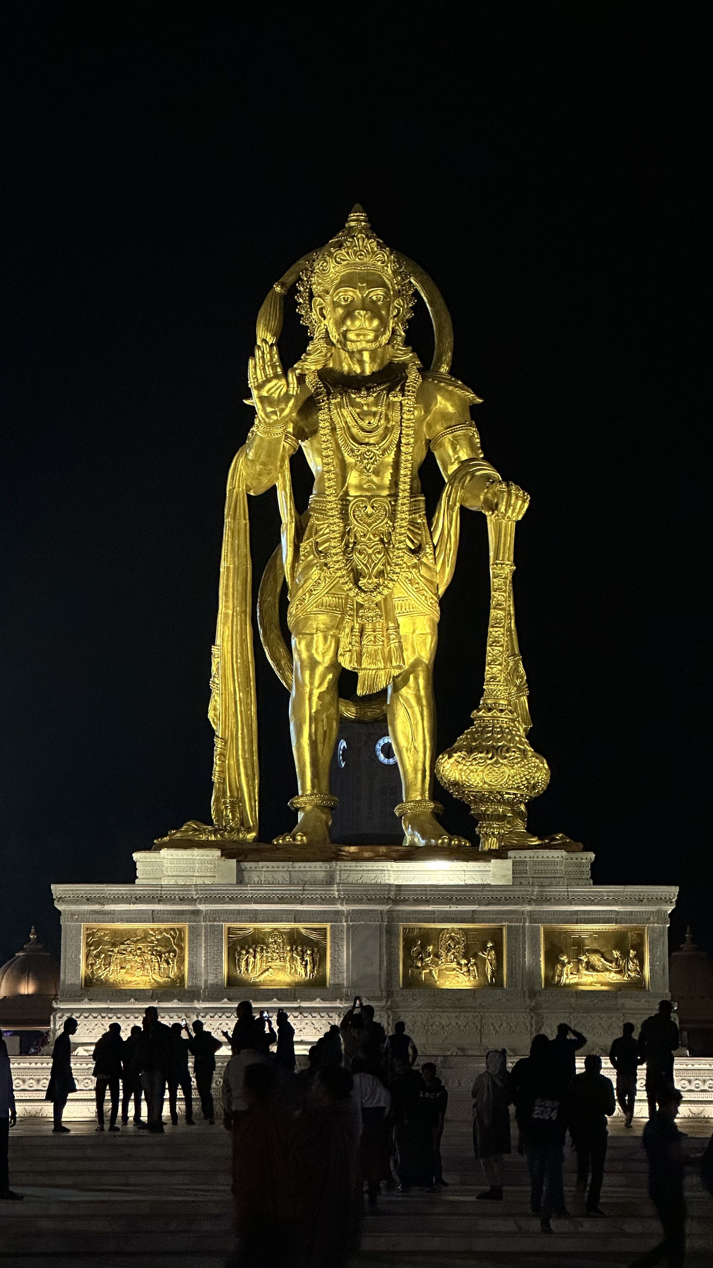 Golden Hanuman statue at night.