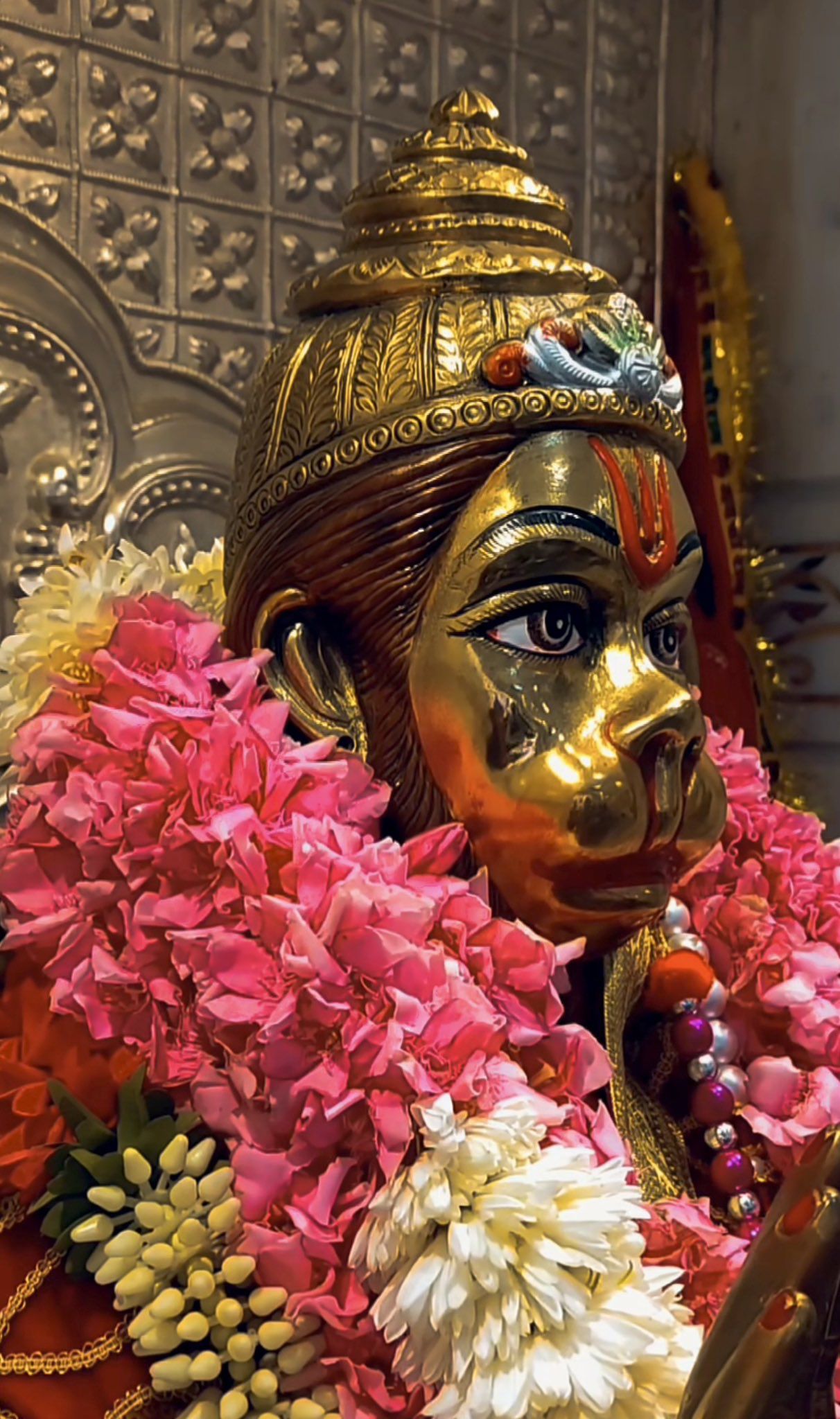 Golden Hanuman face with flower garland