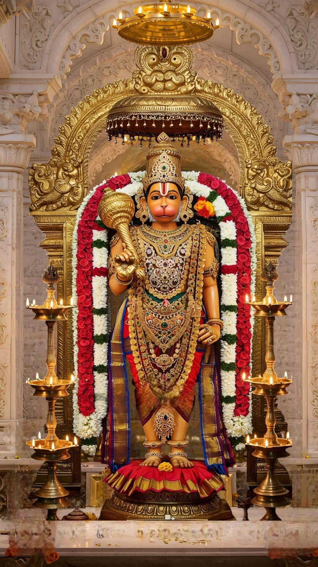 Hanuman idol adorned with gold and flowers.