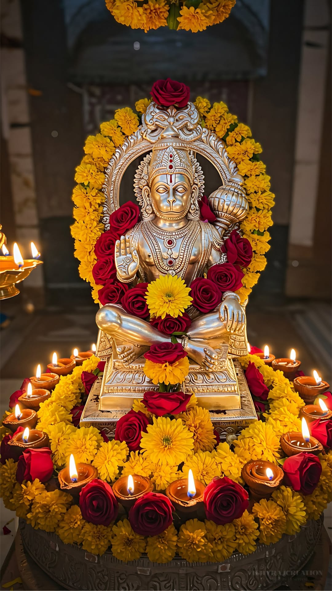 Hanuman idol surrounded by flowers and diyas