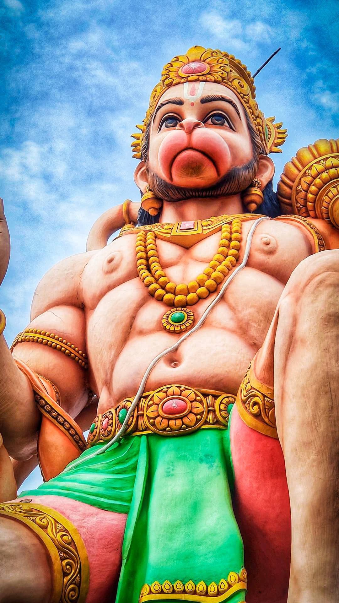 Powerful Hanuman statue against cloudy sky