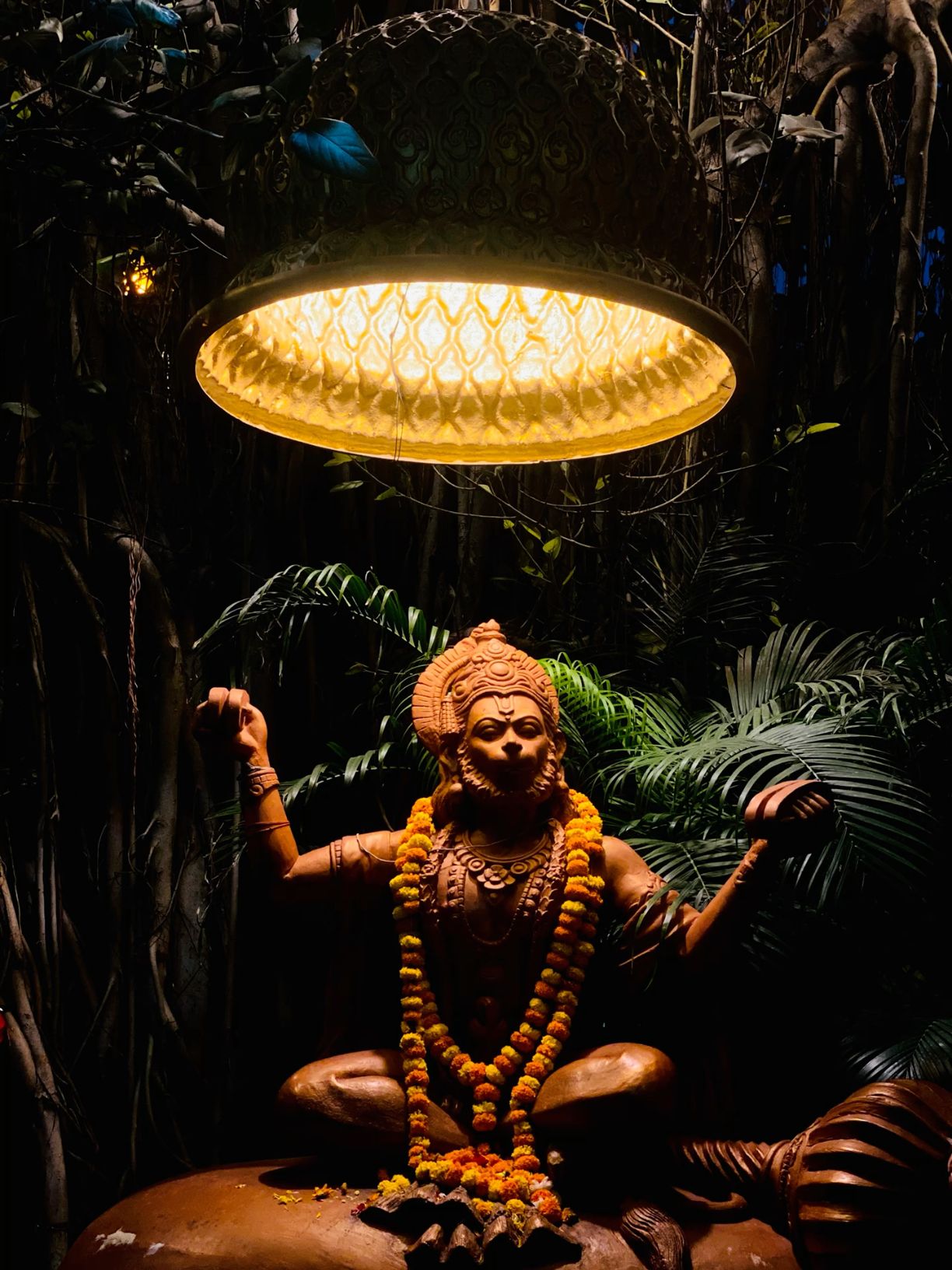 Hanuman statue adorned with marigolds.