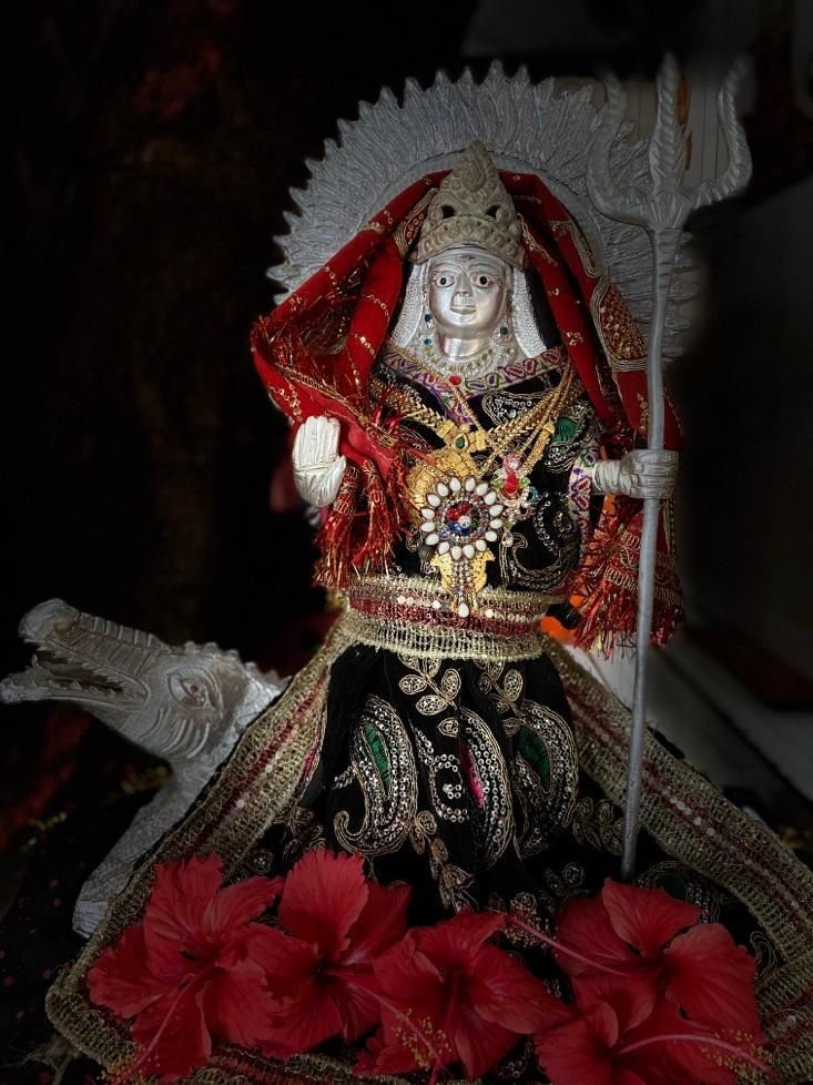 Khodiyar Maa silver statue with red flowers