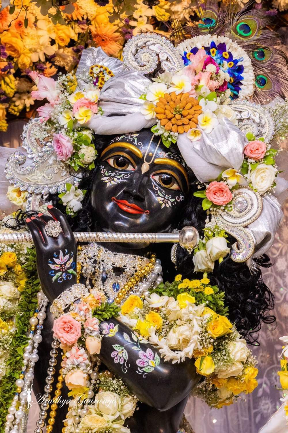 Lord Krishna playing flute surrounded by flowers