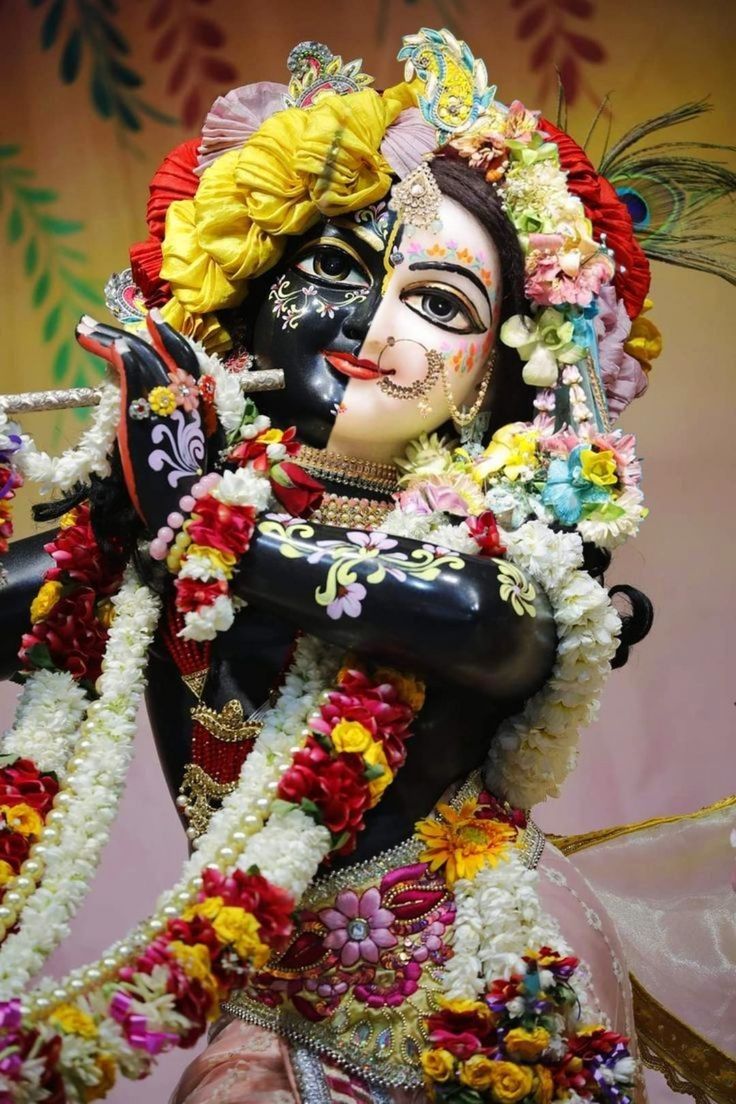 Lord Krishna playing the flute adorned with flowers