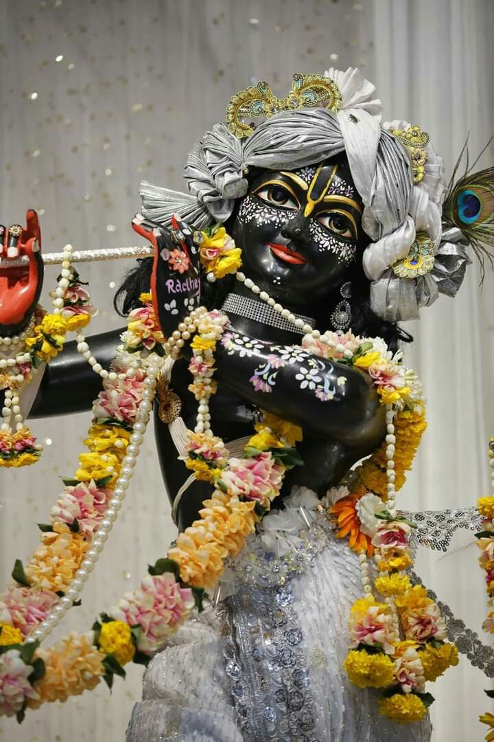 Krishna playing flute adorned with flowers