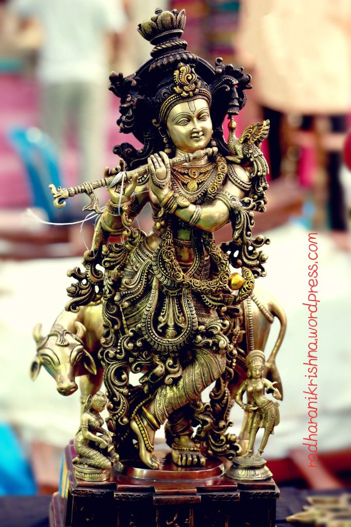 Golden Krishna statue playing flute.