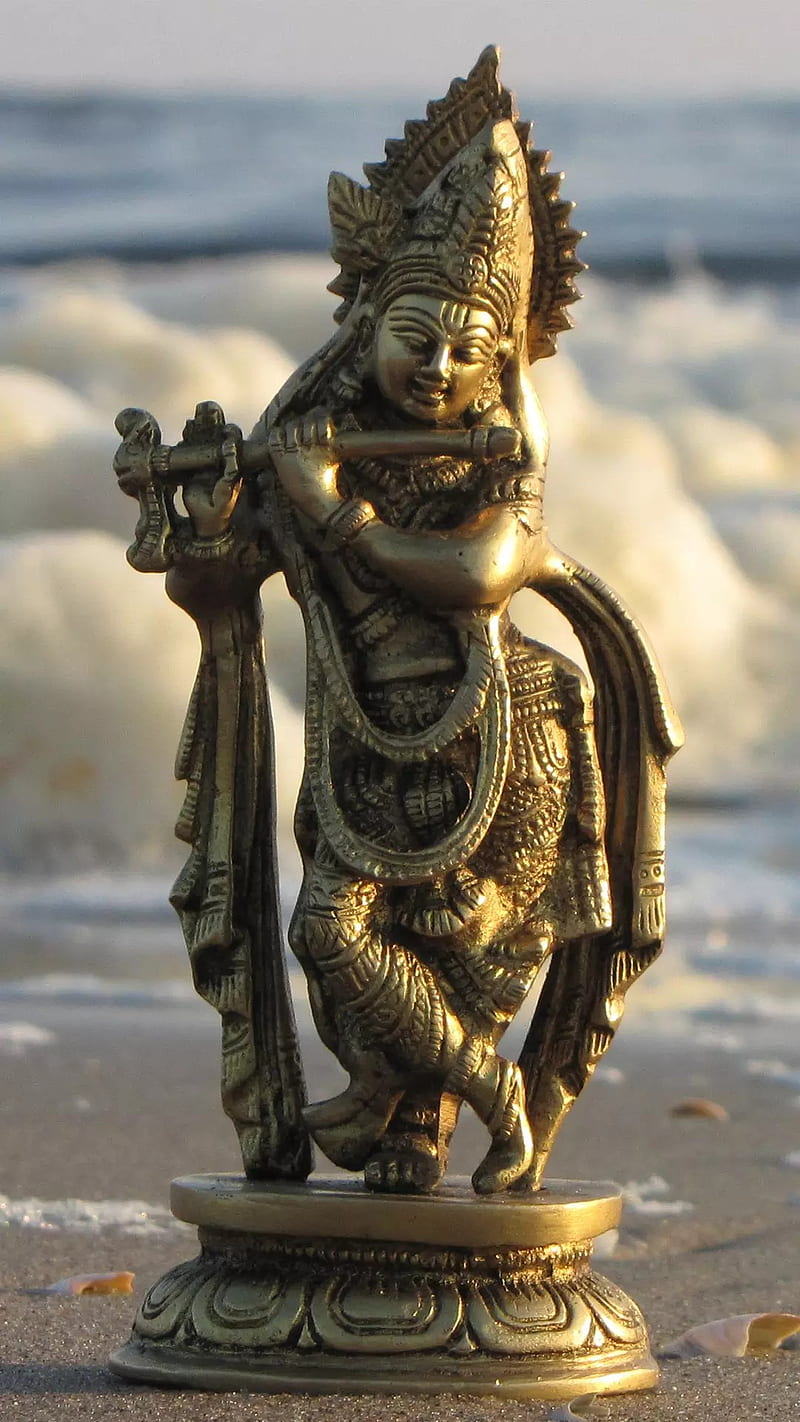 Krishna playing flute on beach
