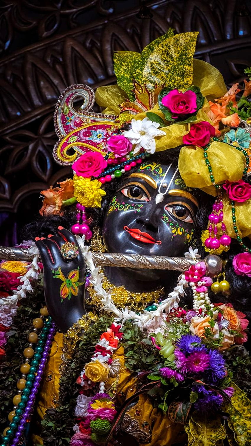 Lord Krishna adorned with vibrant flowers.