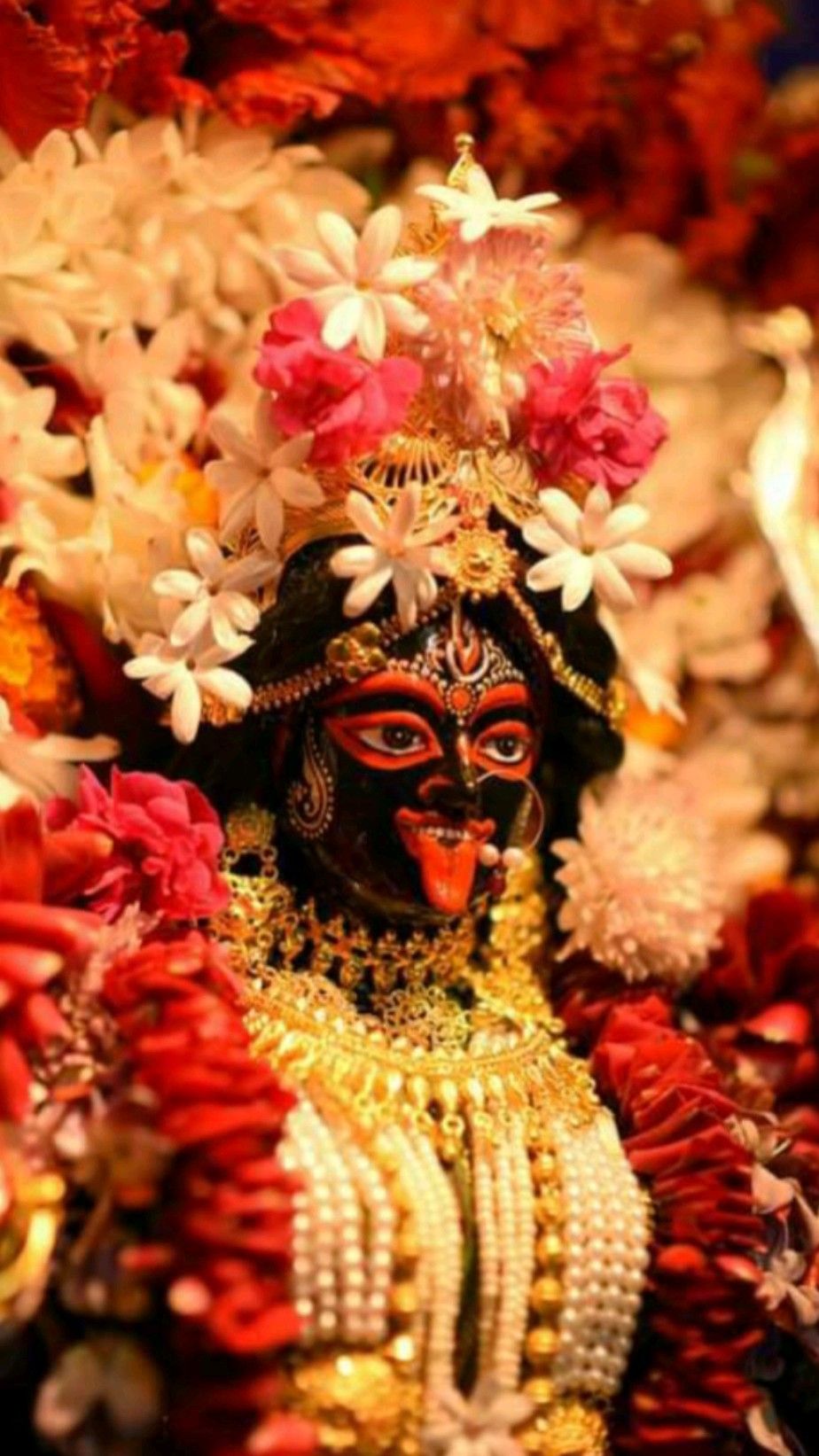 Goddess Kali adorned with vibrant flowers.