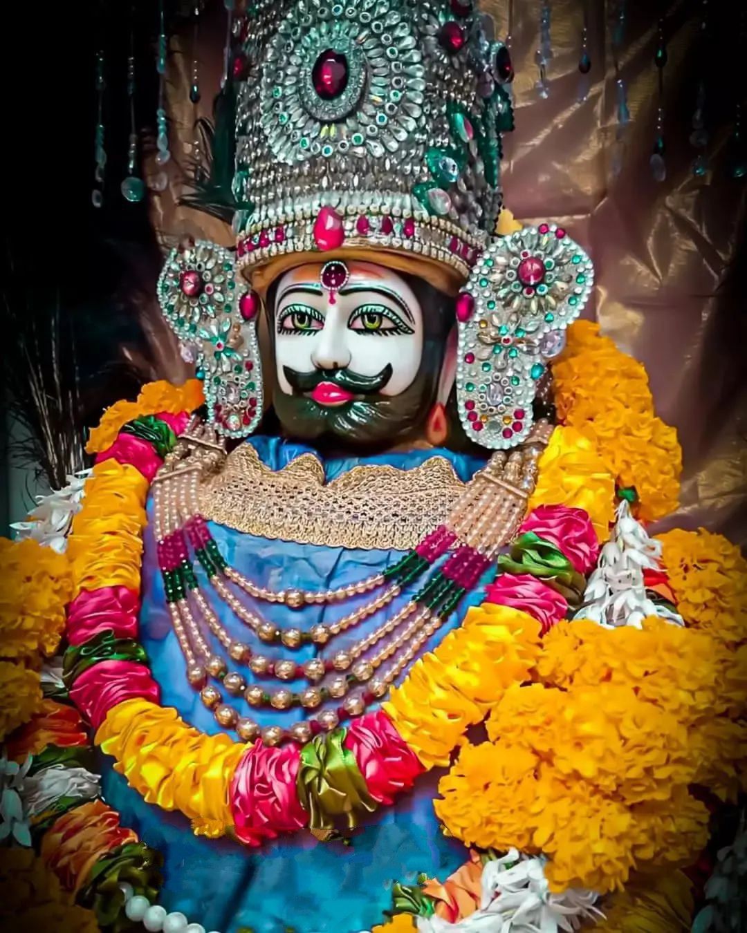 Close-up portrait of Ramdevpir adorned with flowers