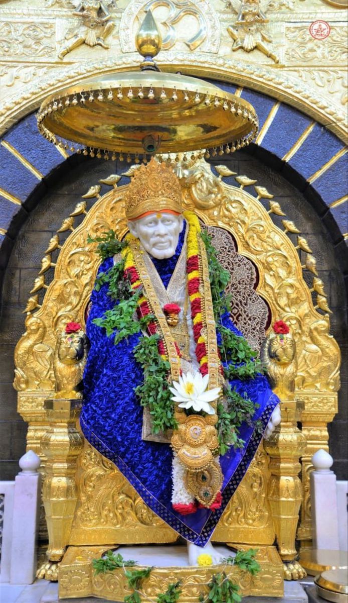 Sai Baba seated on golden throne.