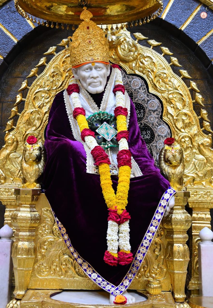Sai Baba seated on golden throne.