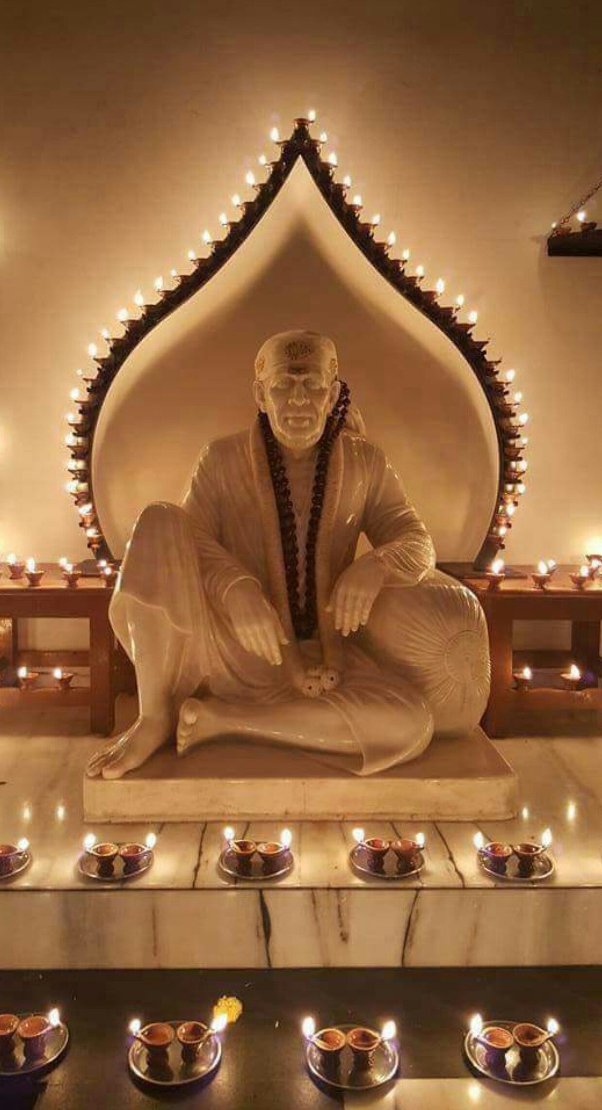 Sai Baba statue surrounded by diyas
