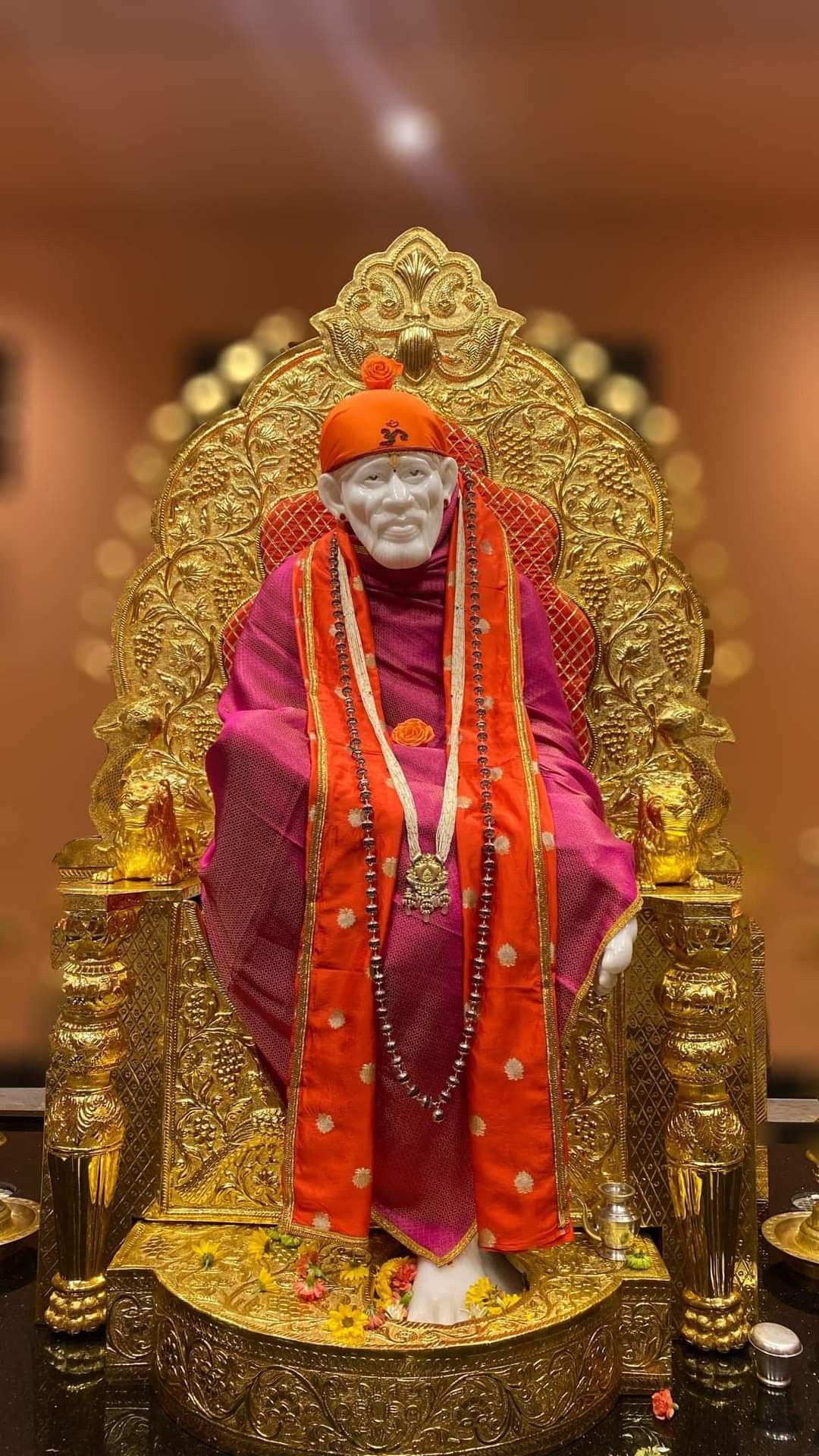 Sai Baba seated on ornate throne