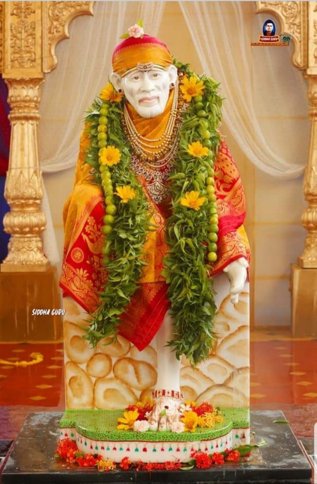 Sai Baba adorned with marigold flowers