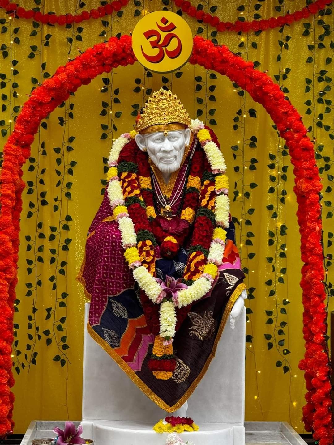 Sai Baba statue adorned with flowers