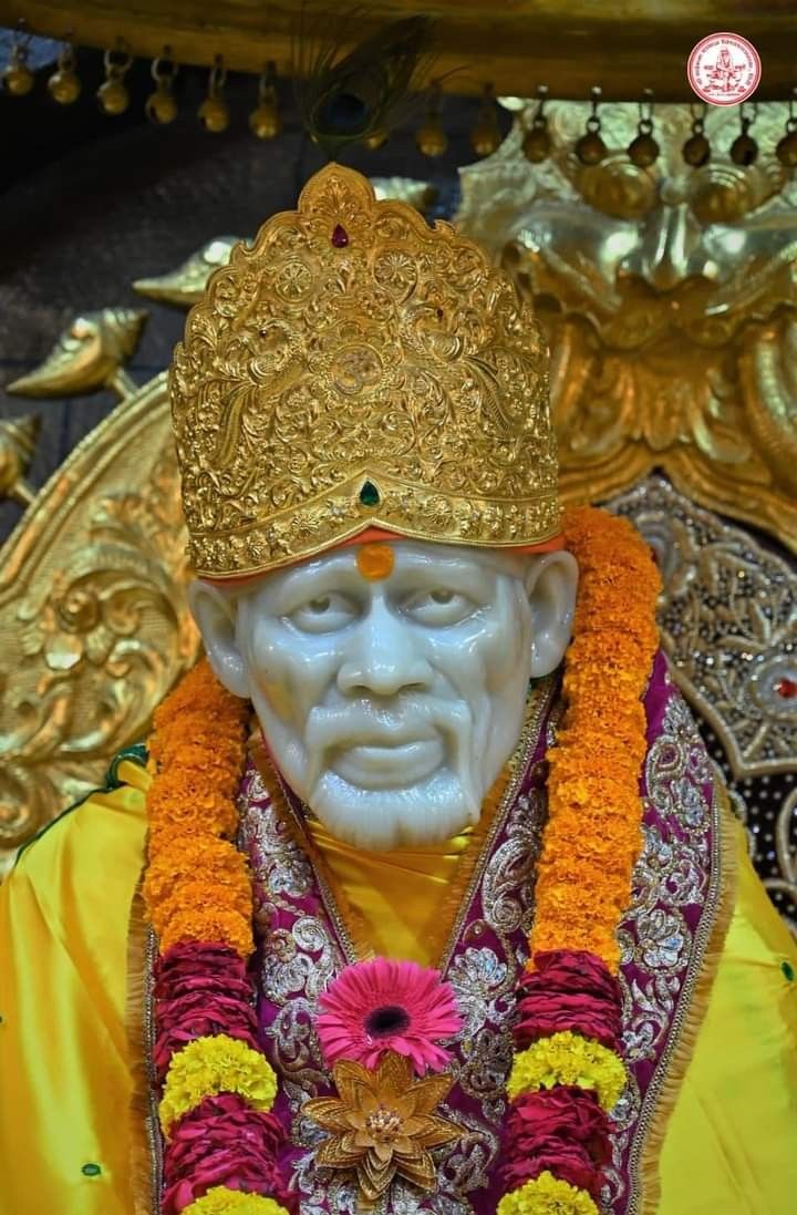 Sai Baba adorned in golden crown.