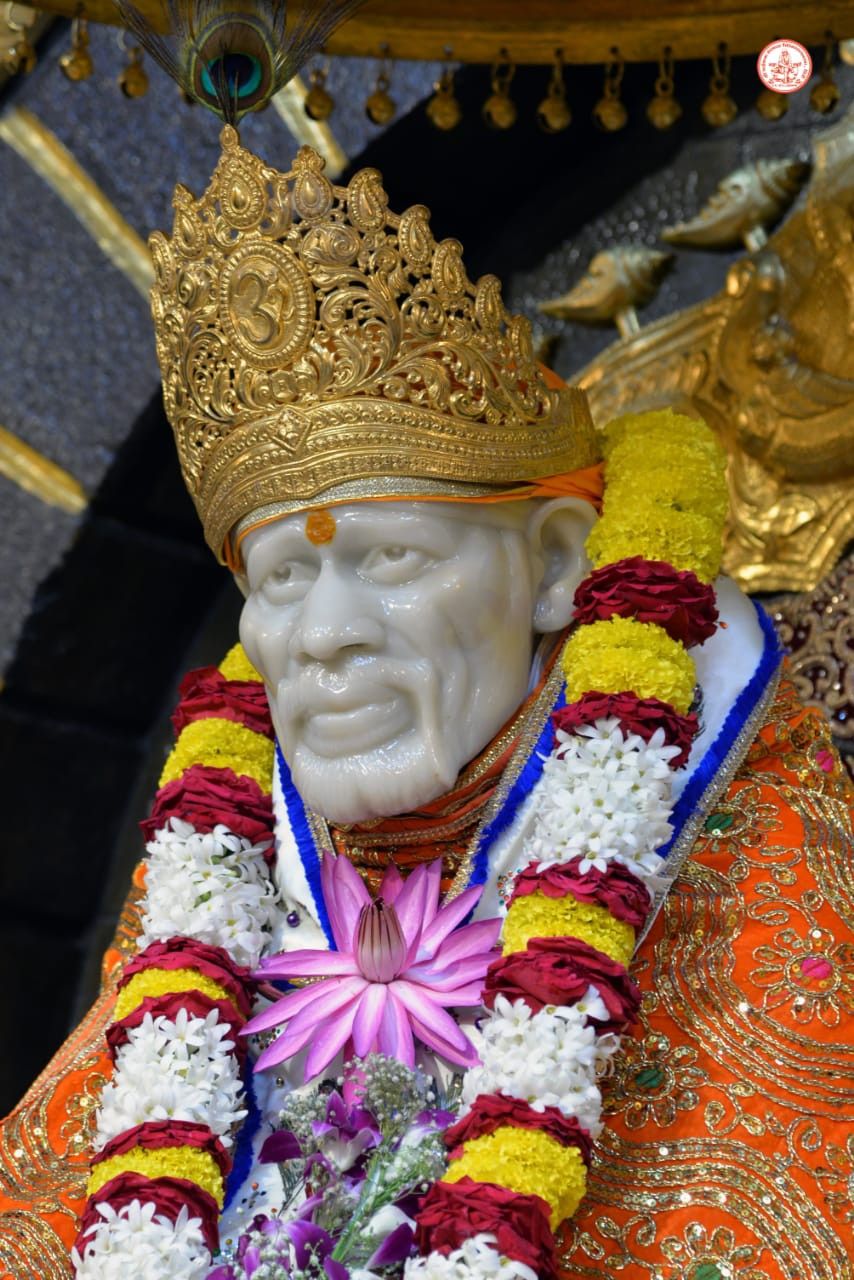 Sai Baba with golden crown, flowers