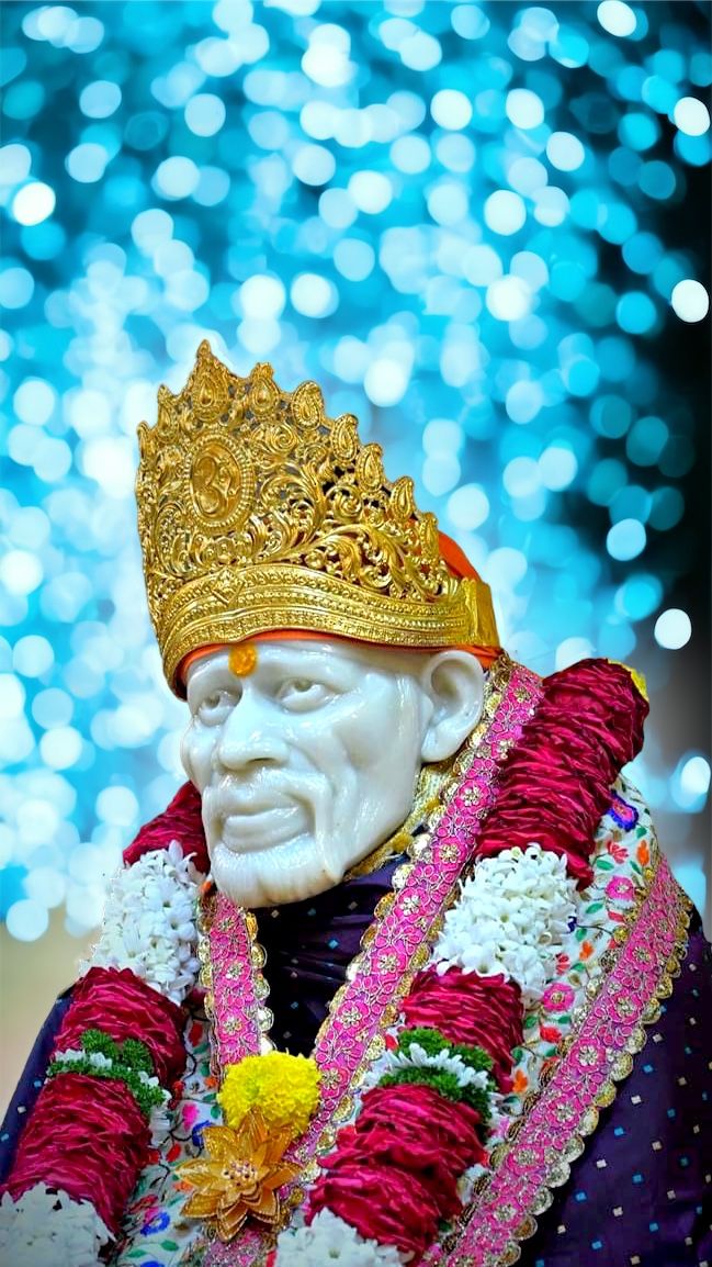Sai Baba with golden crown and flowers.