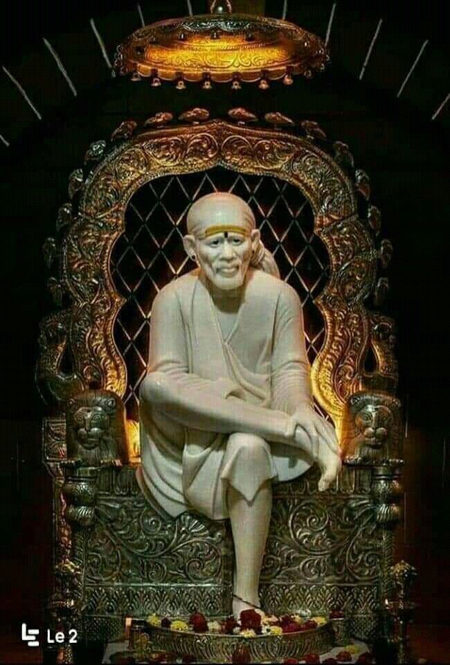 Sai Baba seated on a golden throne.