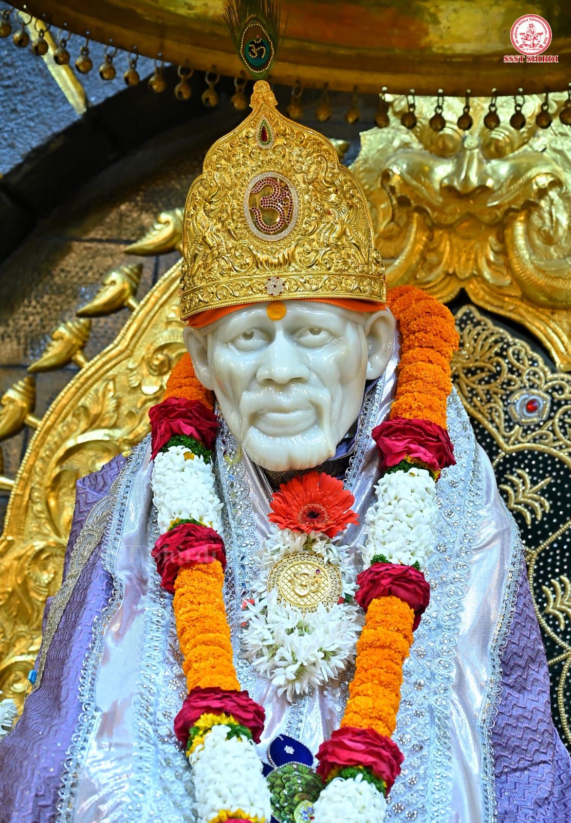 Sai Baba in golden crown and garlands