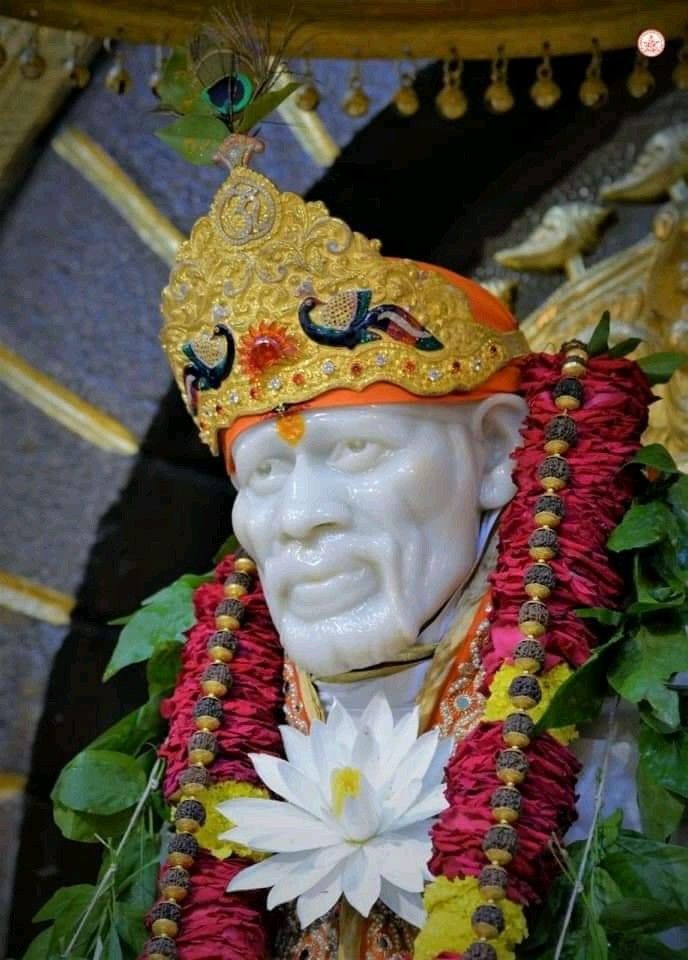 Sai Baba with floral garland and crown.
