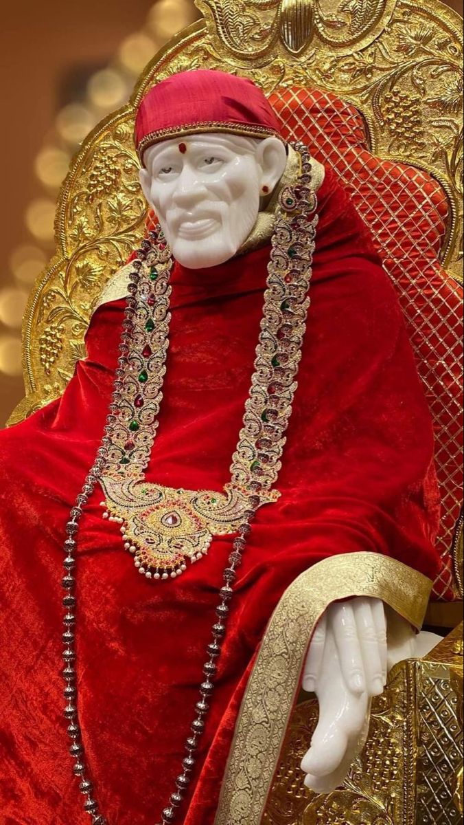 Sai Baba statue adorned in red.