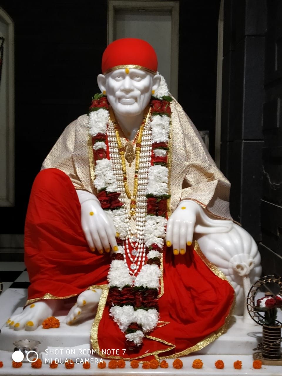 Marble statue of Sai Baba adorned flowers