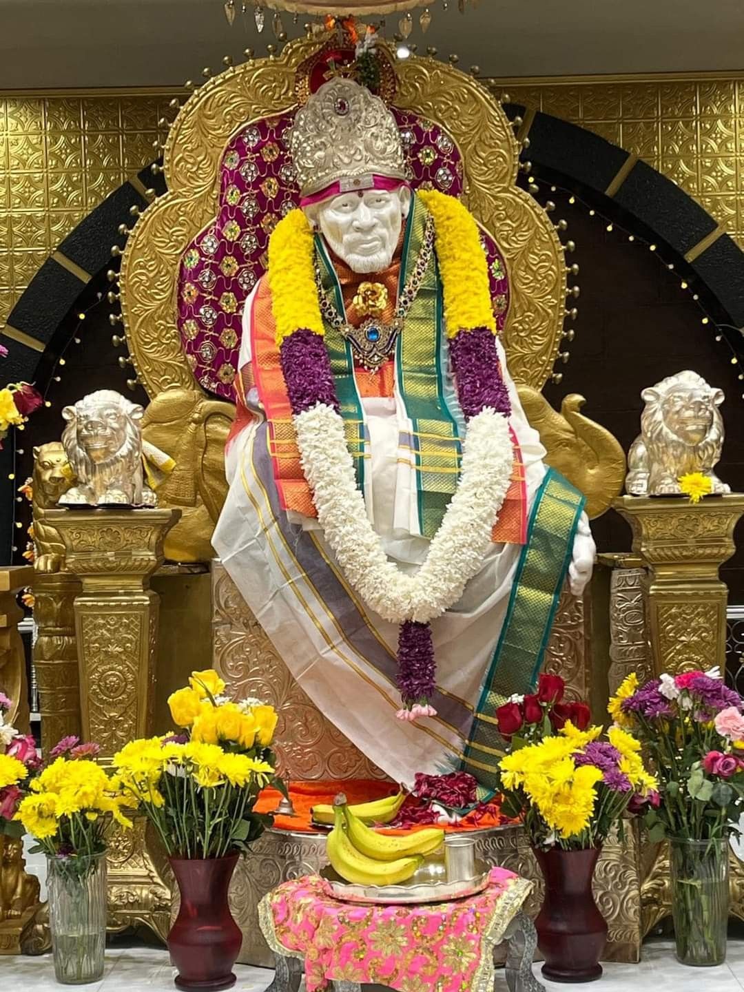 Sai Baba statue with flowers offerings.